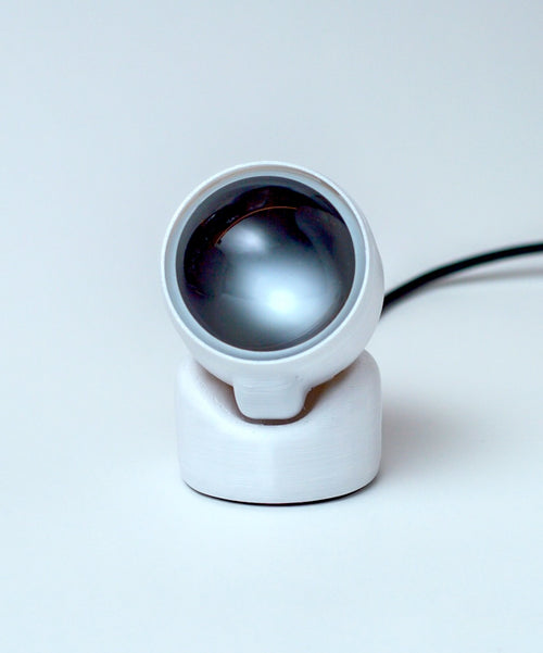 White camera lens on a light gray background